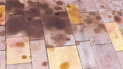 Olejové škvrny na dlažobných kockách pred domom.