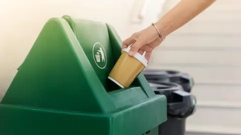 Vyhadzovanie papierového pohára na kávu do koša
