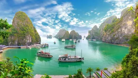 Zátoka Ha Long s loďami a vápencovými skalami, pohľad z ostrova Bo Hon vo Vietname