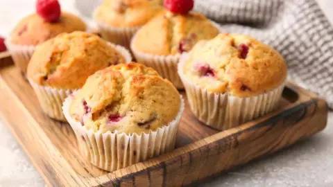 Jogurtové muffiny s malinami a bielou čokoládou na drevenom podnose