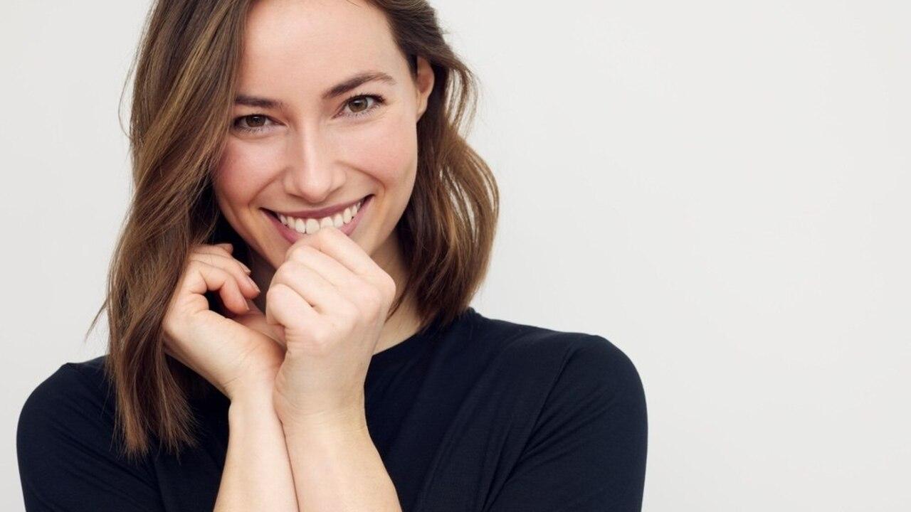 Usmievavá žena s prefíkaným pohľadom, ktorý naznačuje sebavedomie a šikovnosť.