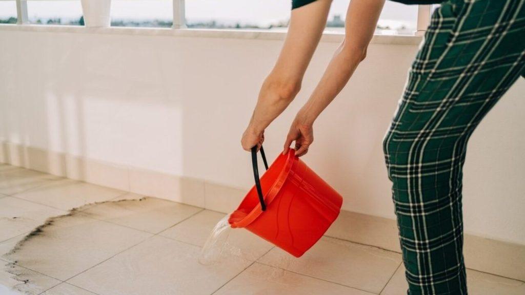 Čistenie balkóna s použitím domácej zmesi vo vedre proti holubom.