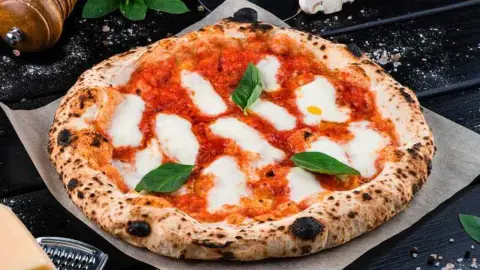 Domáca pizza s mozzarellou a paradajkovým základom na stole