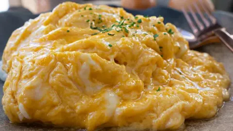 Krémová praženica posypaná pažítkou na tanieri, pripravená podľa jednoduchého receptu.