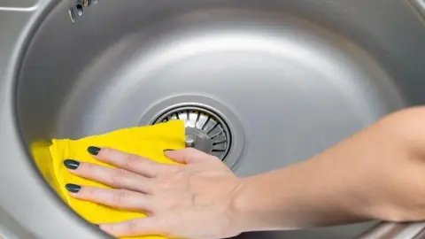 Finálne leštenie nerezového drezu žltou handričkou pre dokonalý lesk