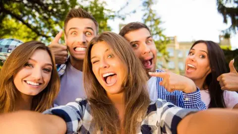 Skupina usmiatych priateľov pózuje na selfie a šíri dobrú náladu