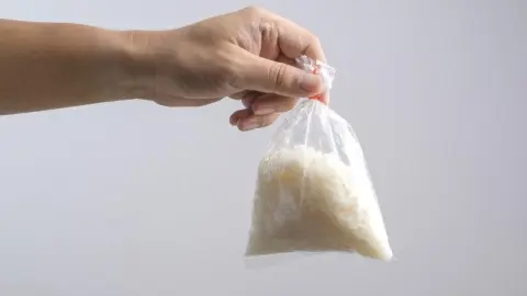 Použité vrecko od ryže pripravené na vyhodenie do koša.