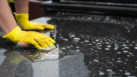 Čistenie pomníka jemnou špongiou na jesennom cintoríne