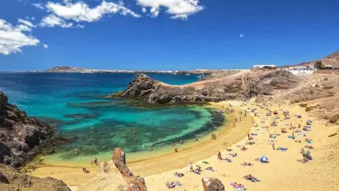 Pláž Papagayo Beach na ostrove Lanzarote s tyrkysovým morom a zlatým pieskom počas jesene.