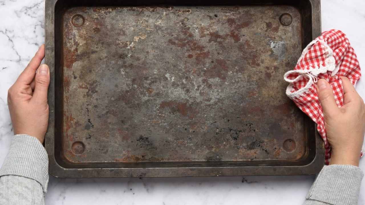 Znečistený plech pred čistením držiavaný v rukách