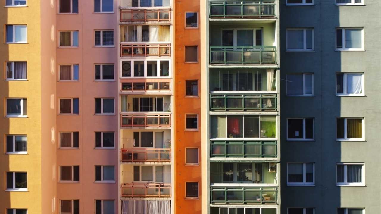 Farebné bytové domy na sídlisku, pohľad na balkóny a okná ako symbol mestského bývania na Slovensku.