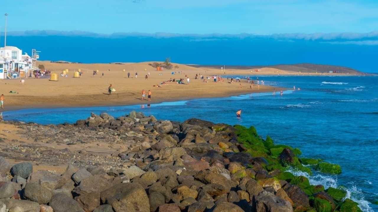 Maspalomas, Španielsko, 22. január 2021: Ľudia si užívajú slnečný deň na pláži Playa de Maspalomas na Gran Canarii, Kanárske ostrovy, Španielsko.