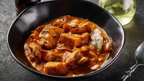 Bravčový guláš v hlbokej miske, podávaný v hustej aromatickej omáčke.