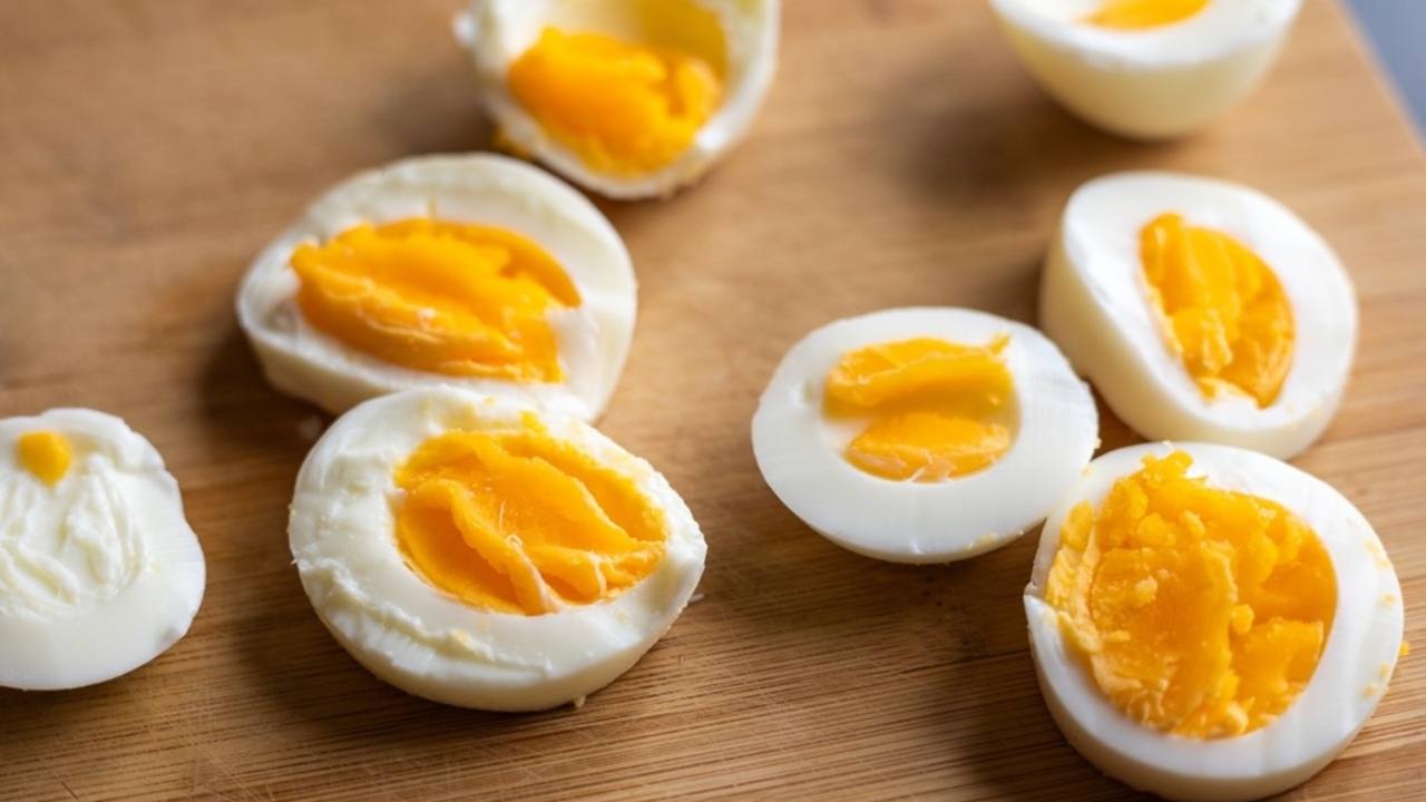 Dokonale uvarené vajcia rozkrojené na doske ukazujú rozdiel v konzistencii žĺtka.