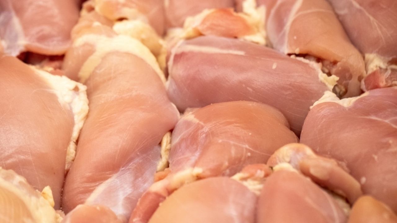 Detail surového kuracieho prsia s výraznými bielymi pruhmi