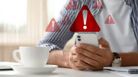 Ruka držiaca telefón so zobrazeným varovaním o napadnutí alebo hackerskom útoku