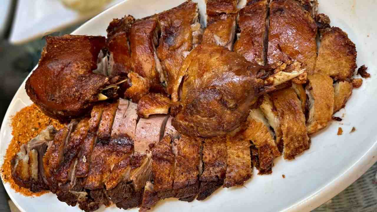 Plátky pečenej husi so zlatistou chrumkavou kožou na servírovacom tanieri.