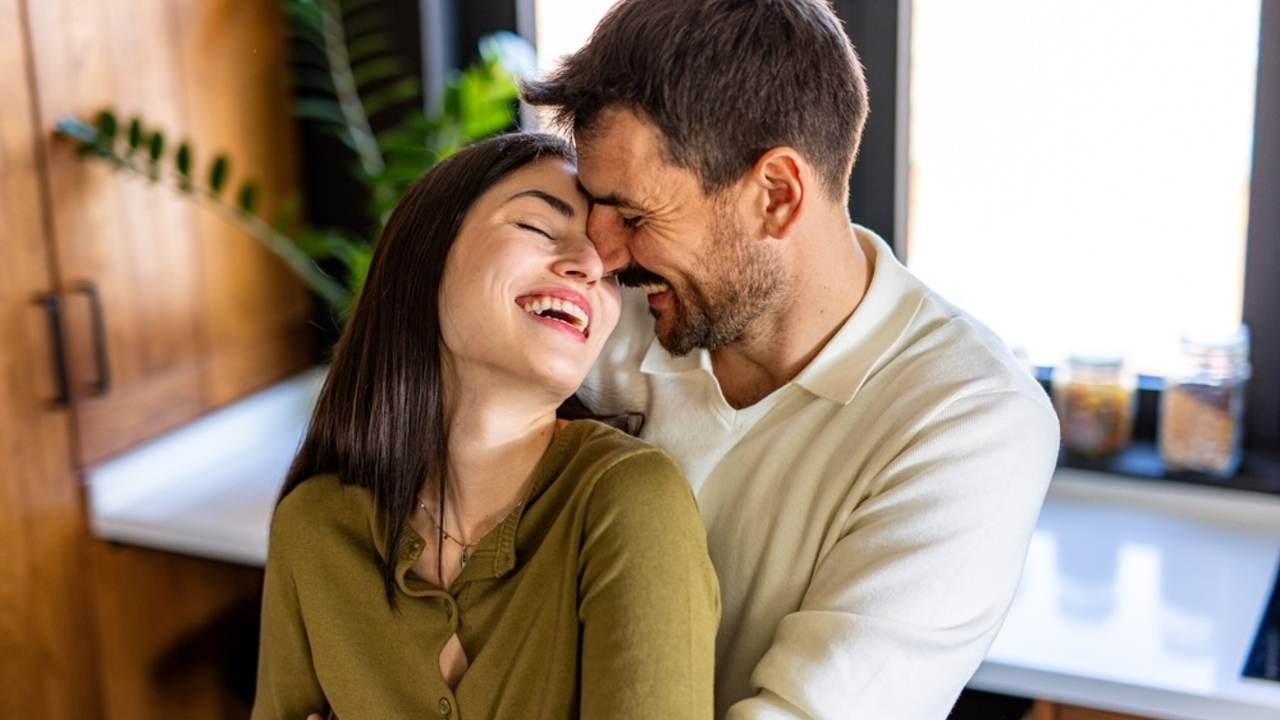 Šťastná dvojica sa spolu smeje v kuchyni.