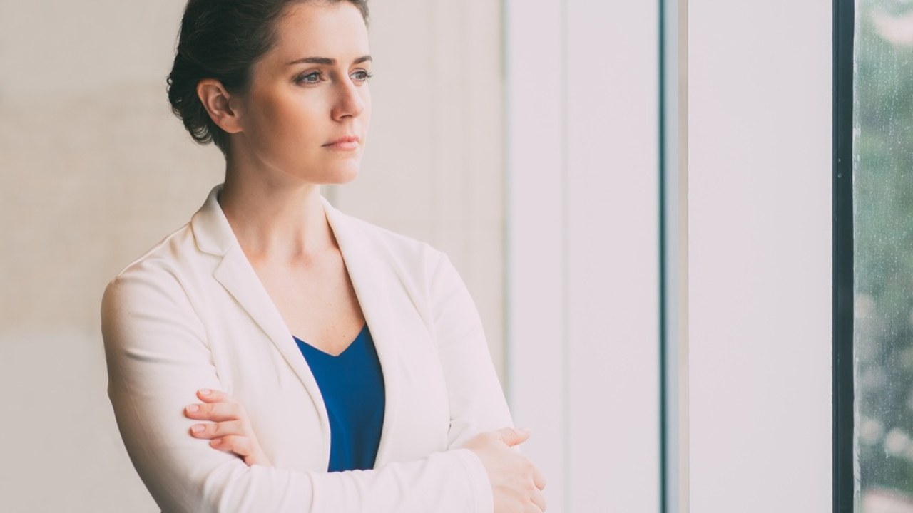 Žena pozerajúca zamyslene z okna, symbolizujúca strach zo šťastia a vnútorný konflikt.