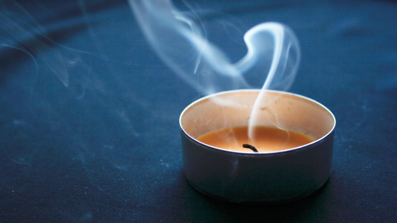 Zhasnutá vonná sviečka so stúpajúcim dymom ako ukážka zhoršenej kvality vzduchu v interiéri