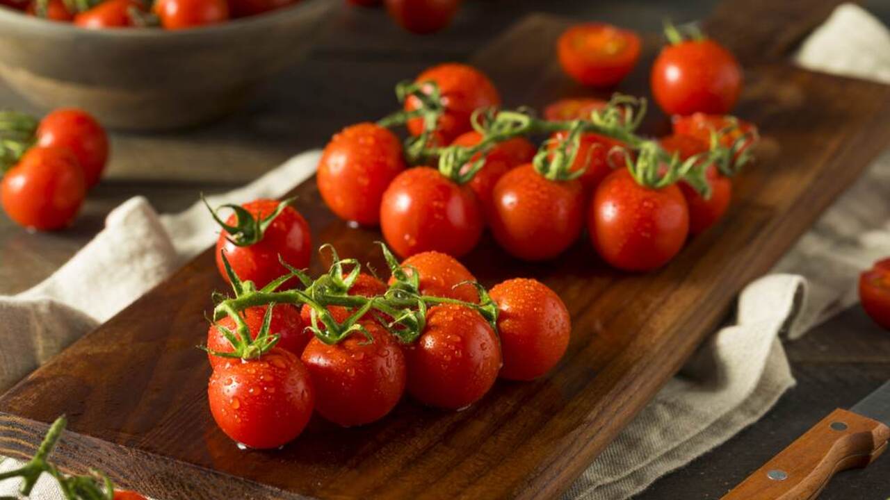 Čerstvé cherry paradajky uložené na drevenej doske na kuchynskom stole