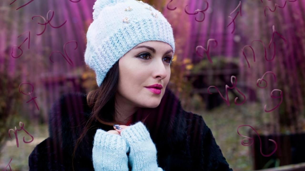 Žena v zimnej čiapke premýšľa počas decembra, okolo nej sú znamenia zverokruhu