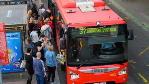 Zamestnanci cestujúci do práce počas rannej špičky v meste.