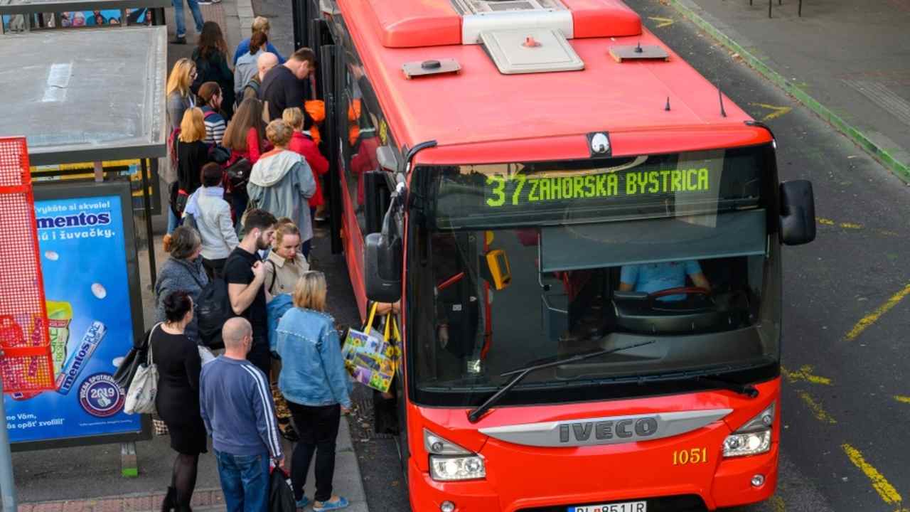 Zamestnanci cestujúci do práce počas rannej špičky v meste.