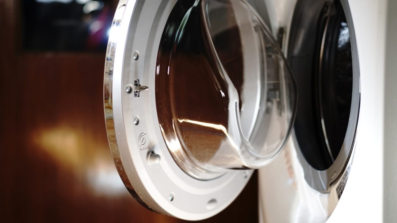 Pootvorené dvierka práčky po skončení prania, pripravené na odvetranie vlhkosti.