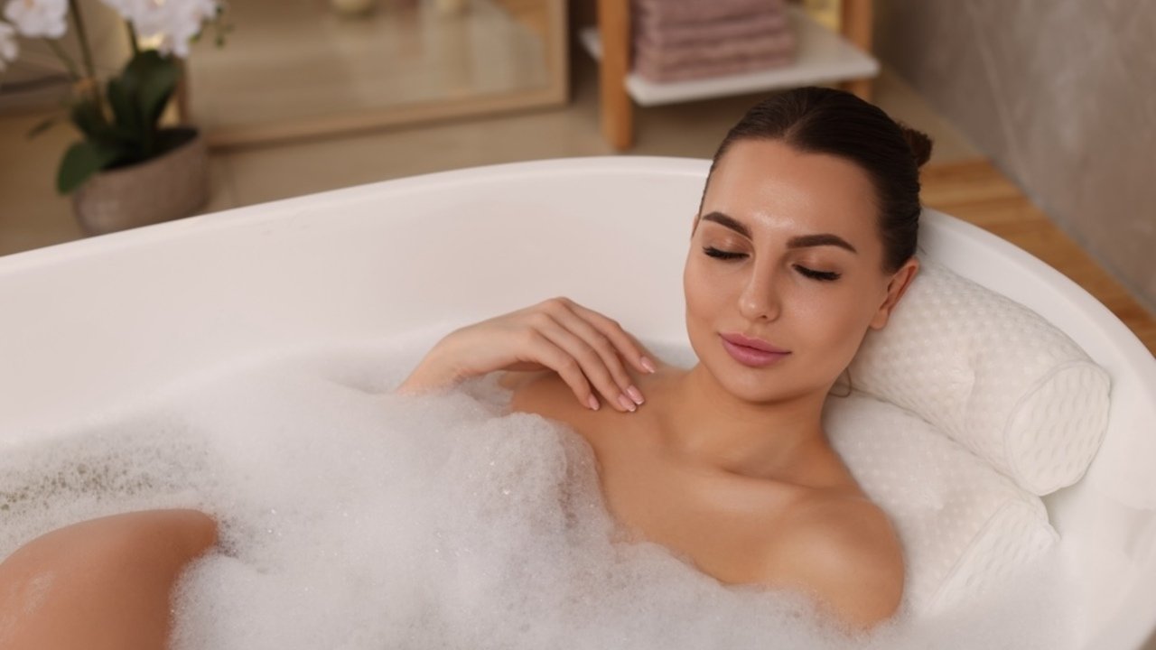 Žena relaxuje v teplom kúpeli s penou v domácej kúpeľni