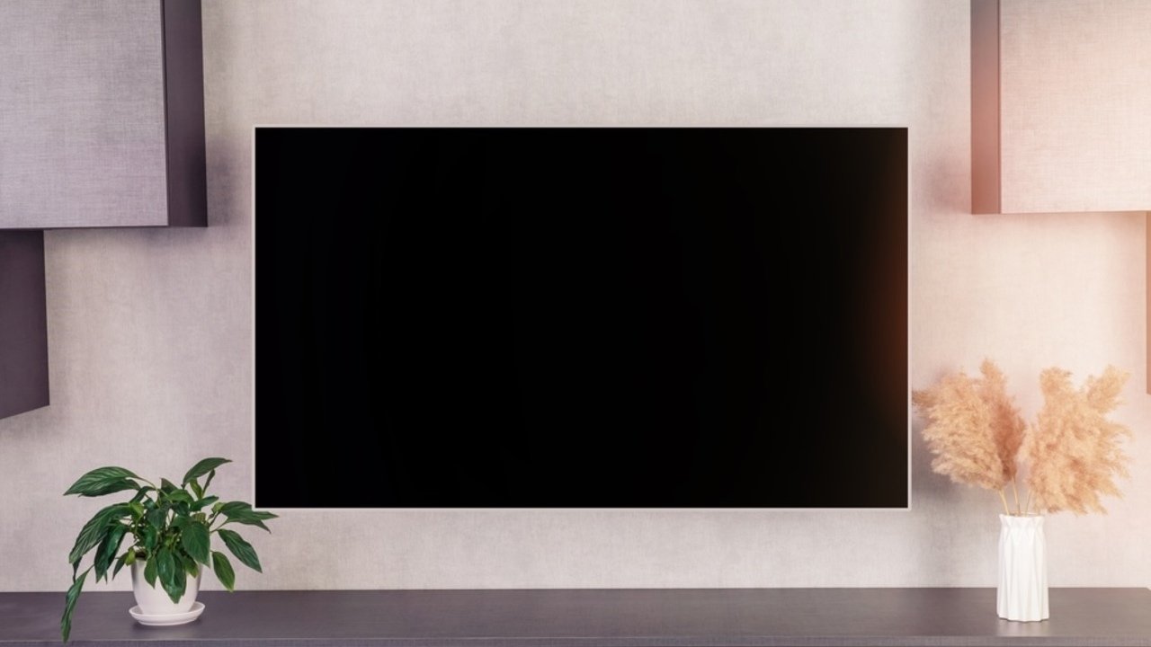 Veľký moderný televízor s prázdnou čiernou LCD obrazovkou zavesený na stene v interiéri domu