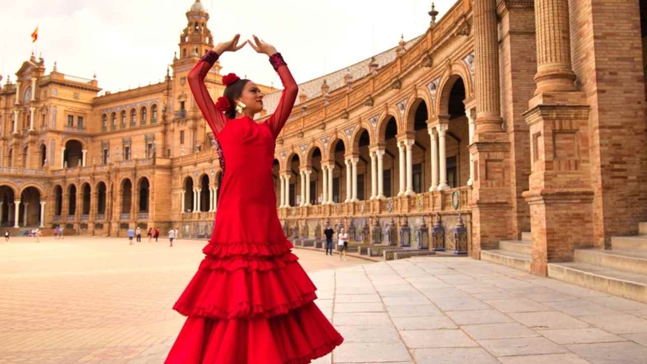 Kr&aacute;sna t&iacute;nedžerka tancuj&uacute;ca flamenco na n&aacute;mest&iacute; v Seville v &Scaron;panielsku. M&aacute; na sebe červen&eacute; &scaron;aty s vol&aacute;nikmi a tancuje flamenco s veľk&yacute;m umen&iacute;m. Flamenco je kult&uacute;rnym dedičstvom ľudstva.