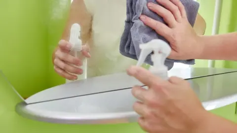 Čistenie kúpeľňového zrkadla pomocou handričky z mikrovlákna