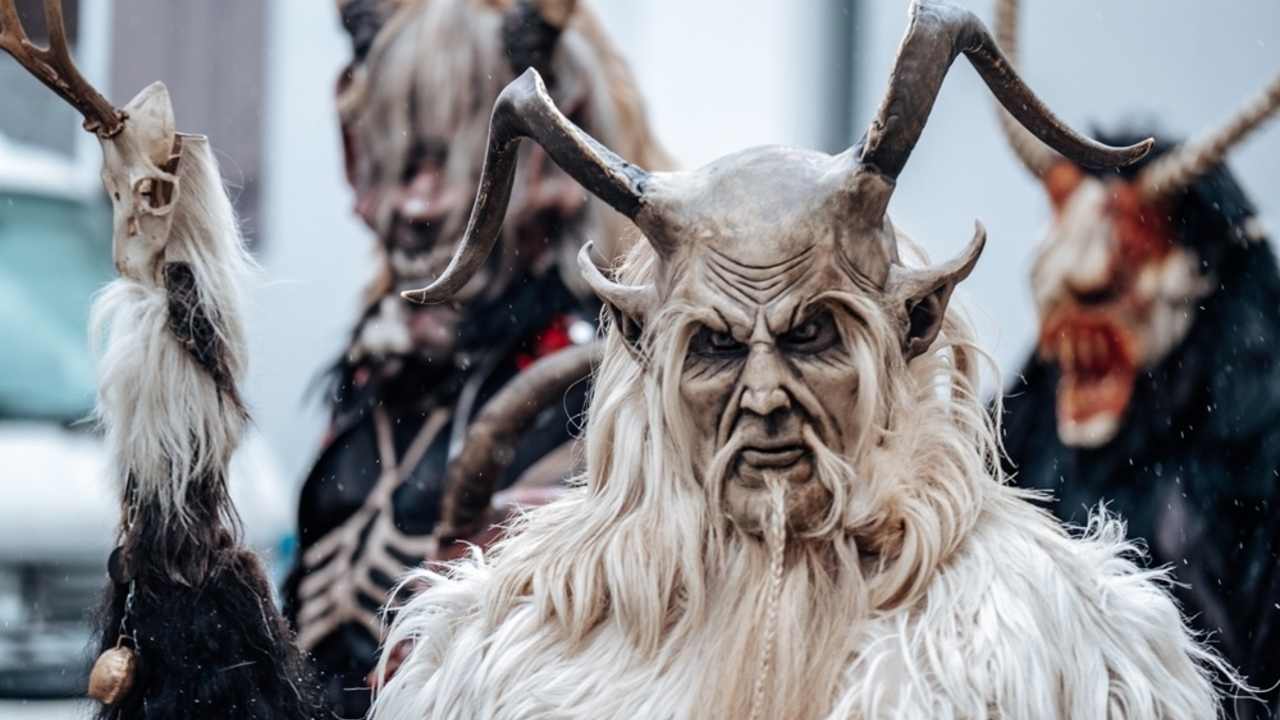 Krampus d&eacute;mon na rozmazanom pozad&iacute; ulice. Zimn&eacute; kost&yacute;mov&eacute; sprievody v uliciach Eur&oacute;py. Karnevalov&eacute; sprievody v Nemecku.