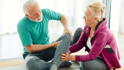 Senior drží boľavé koleno po nevhodnom cvičení