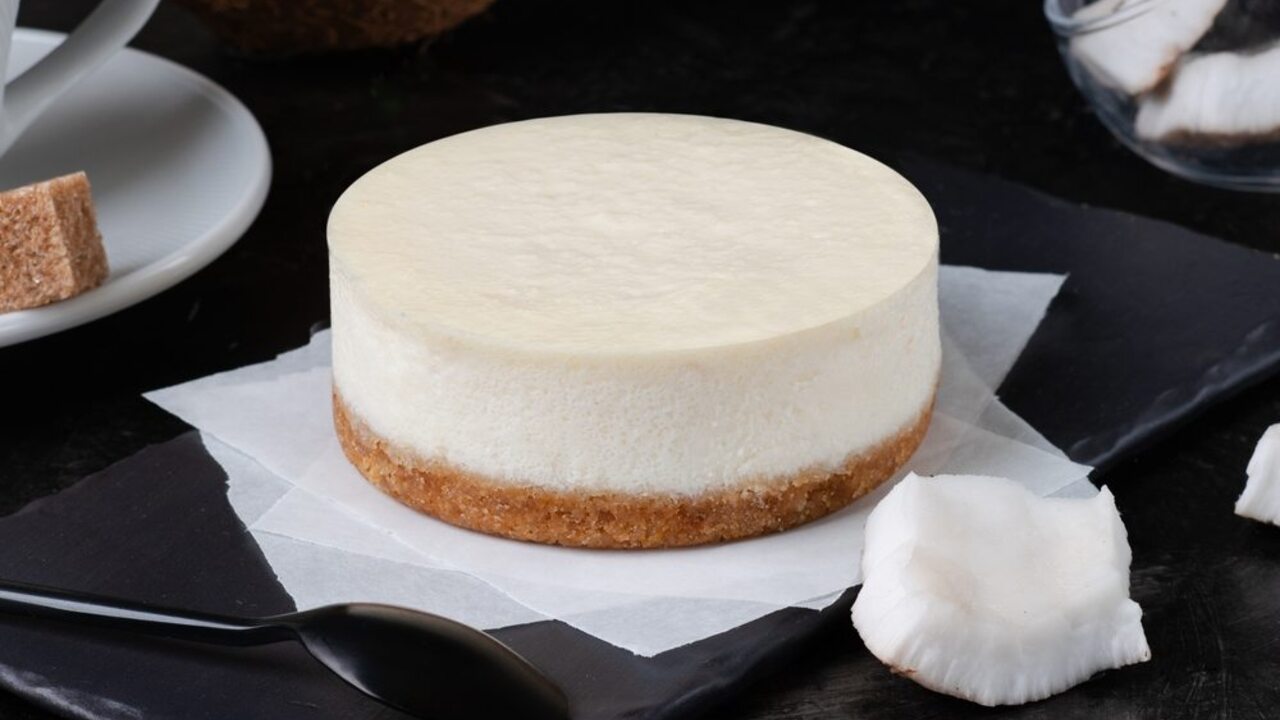 Kokosový dezert bez pečenia s krémovou vrstvou a sušienkovým korpusom, podávaný na podnose.