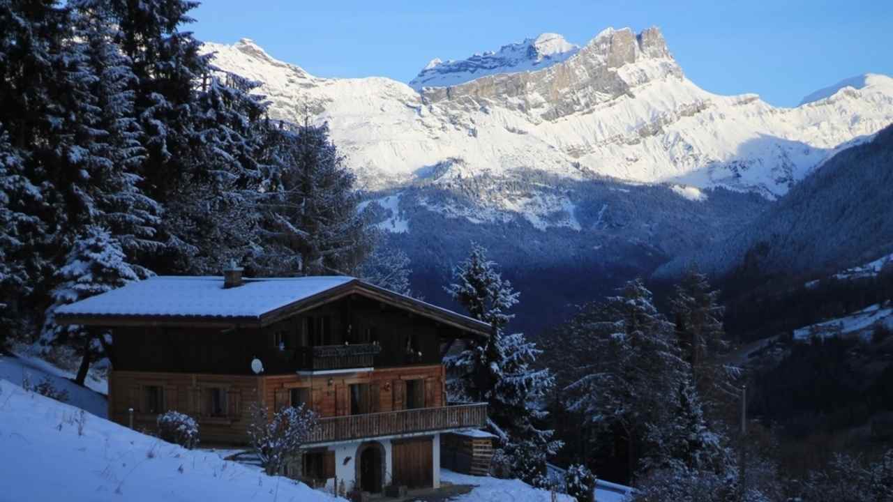 Drevená chata v švajčiarskych Alpách zasnežená v zimnom období