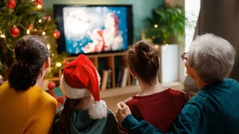 Rodina sledujúca vianočný film v obývačke