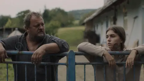 Scéna z filmu Potopa: otec a dcéra pri bráne v rusínskej dedine