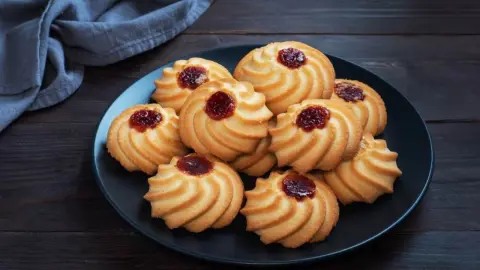 Krehké pudingové sušienky s marmeládou na tmavom tanieri
