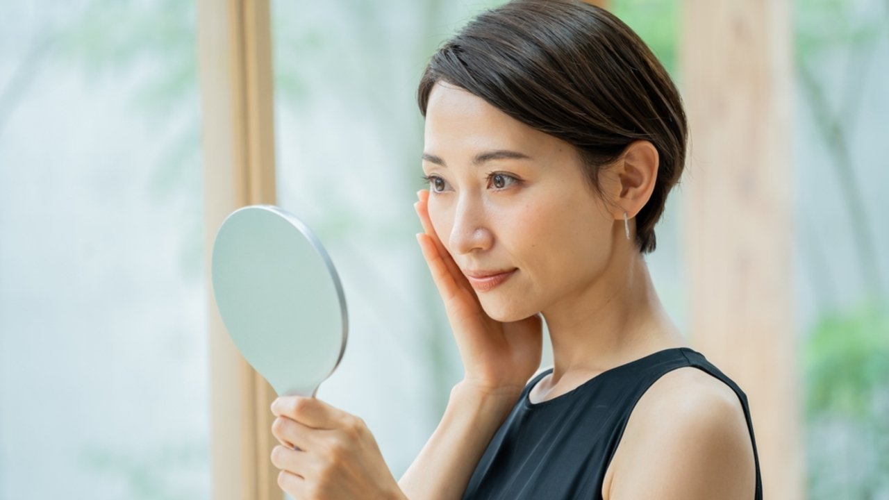 Japonka pri rannej skincare rutine pred zrkadlom