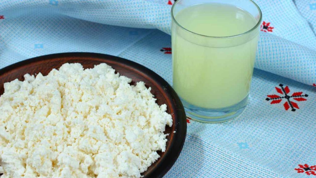 Tvaroh a srvátka na tmavom drevenom pozadí