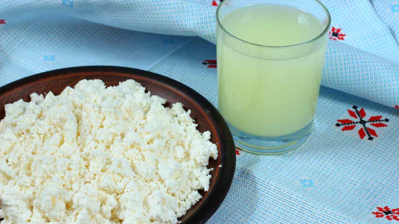 Tvaroh a srvátka na tmavom drevenom pozadí