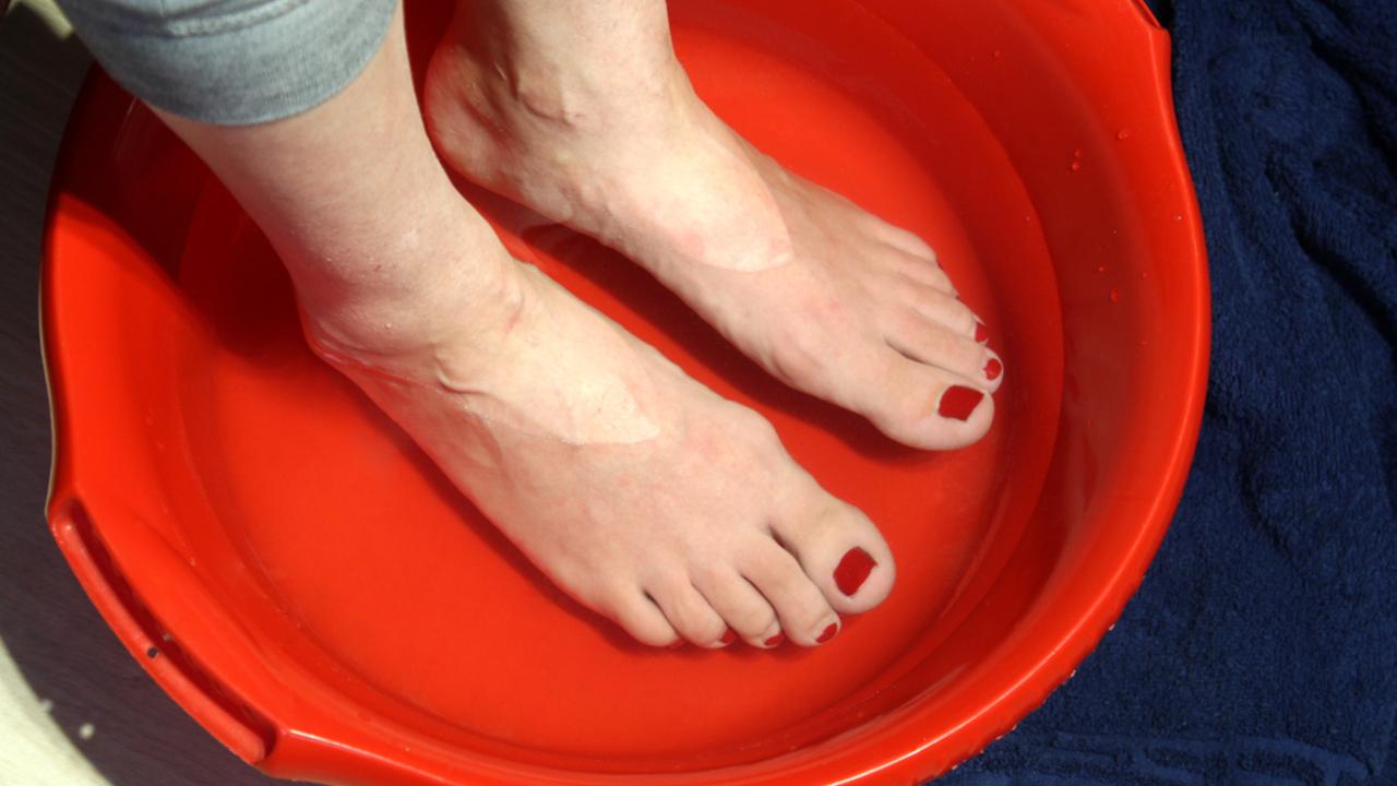ženské nohy sa vyvaľujú v miske s teplou vodou