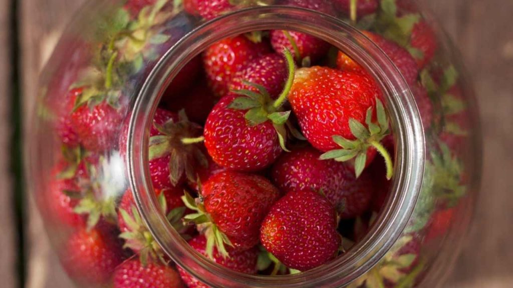 čerstvé farmárske jahody v sklenenej nádobe, pohľad zhora