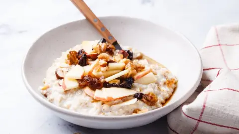 Bircher muesli s jablkami, hrozienkami a orechmi. Koncept zdravých raňajok.