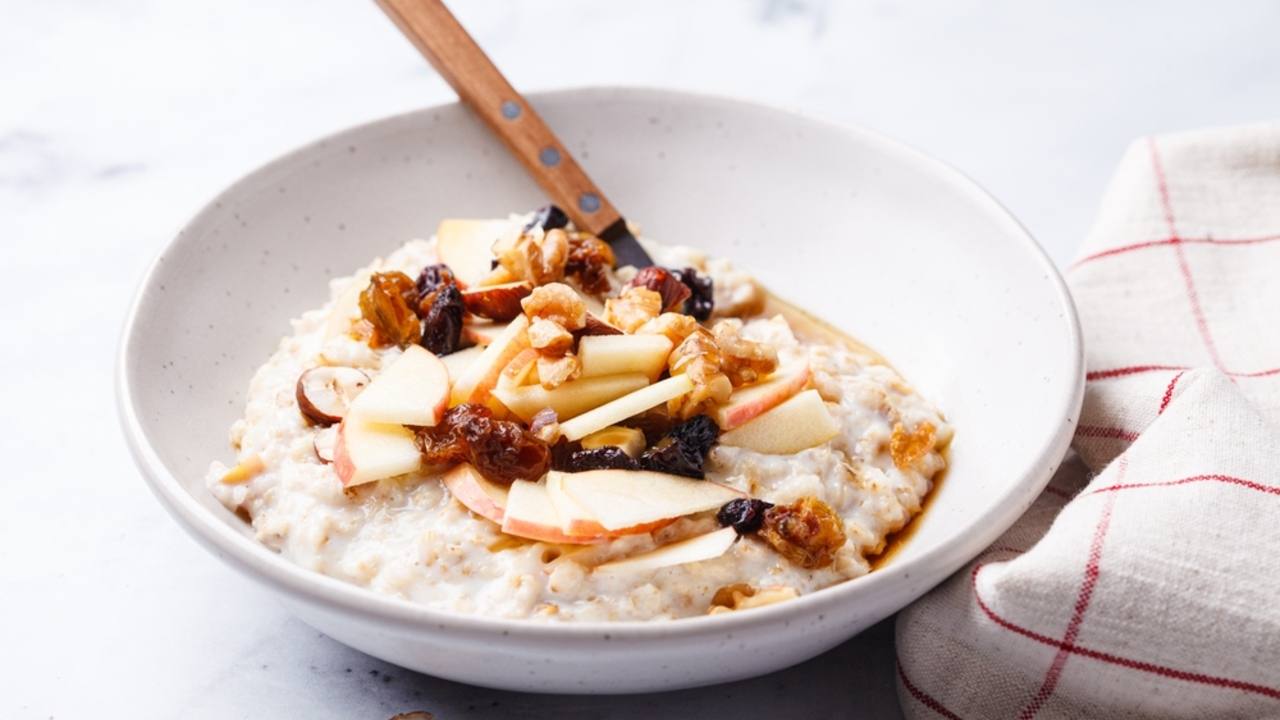 Bircher muesli s jablkami, hrozienkami a orechmi. Koncept zdravých raňajok.