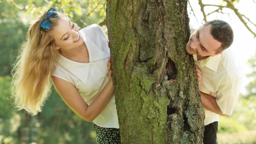 Koncept lásky a romantických prechádzok. Muž a blondínka na romantickom rande v parku, šťastní, že sú spolu.