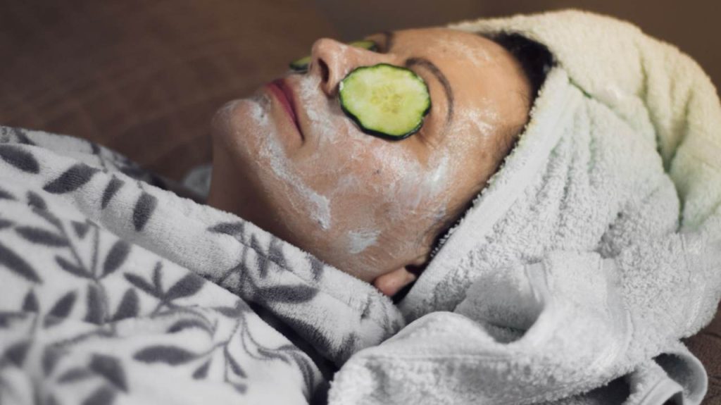 Zrelá žena s maskou a uhorkou na tvári