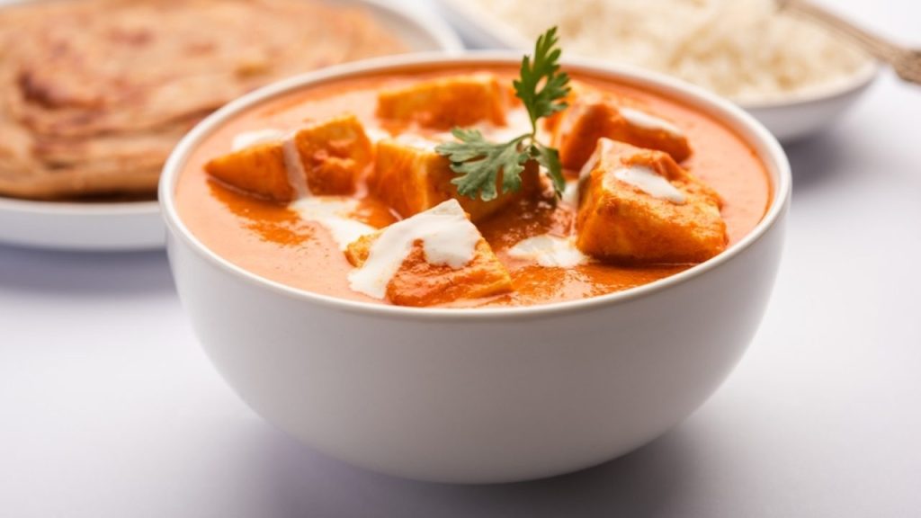 Paneer Butter Masala or Cheese Cottage Curry podávané s ryžou a laccha paratha